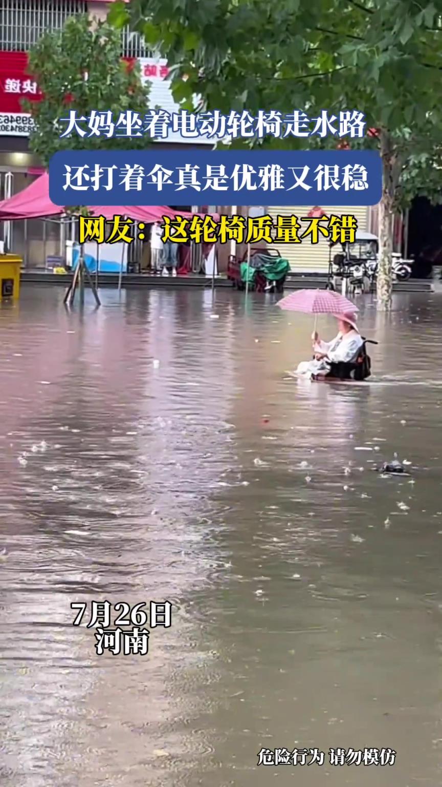 大妈坐着电动轮椅走水路，还打着伞真是优雅又很稳