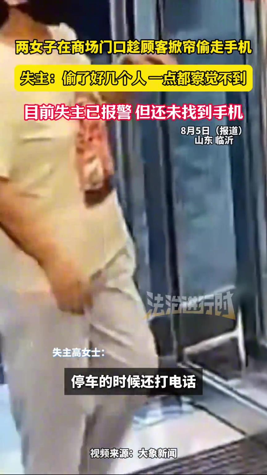 两女子在商场门口趁顾客掀帘偷走手机