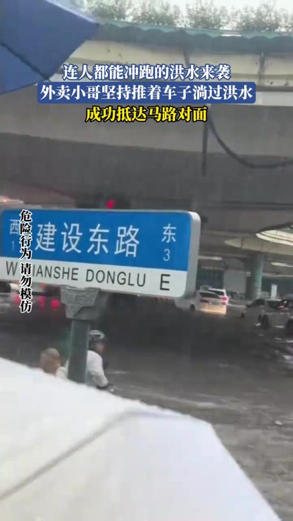 连人都能冲跑的洪水来袭，外卖小哥坚持推着车子淌过洪水