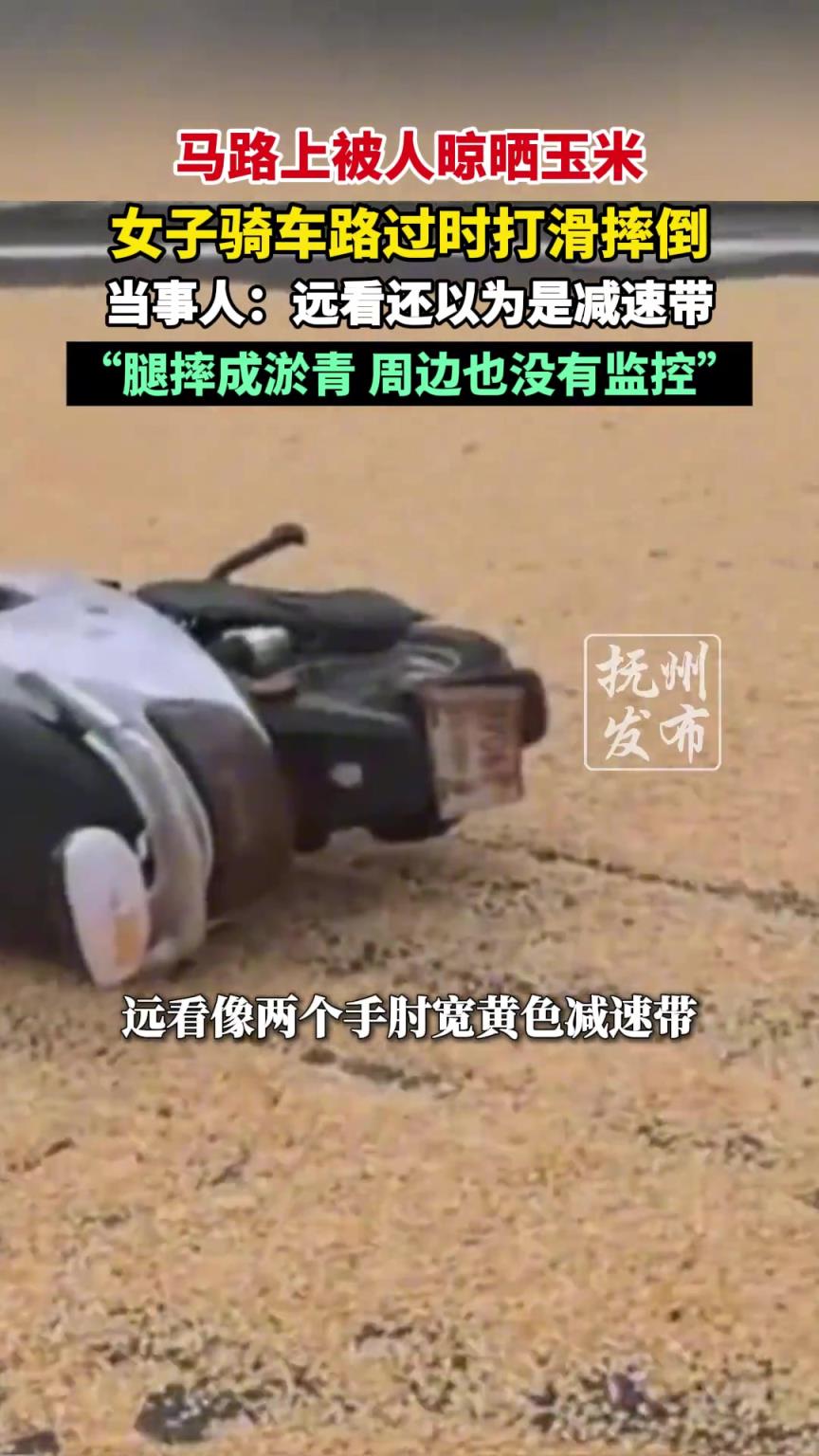 马路上被人晾晒玉米，女子骑车路过时打滑摔倒