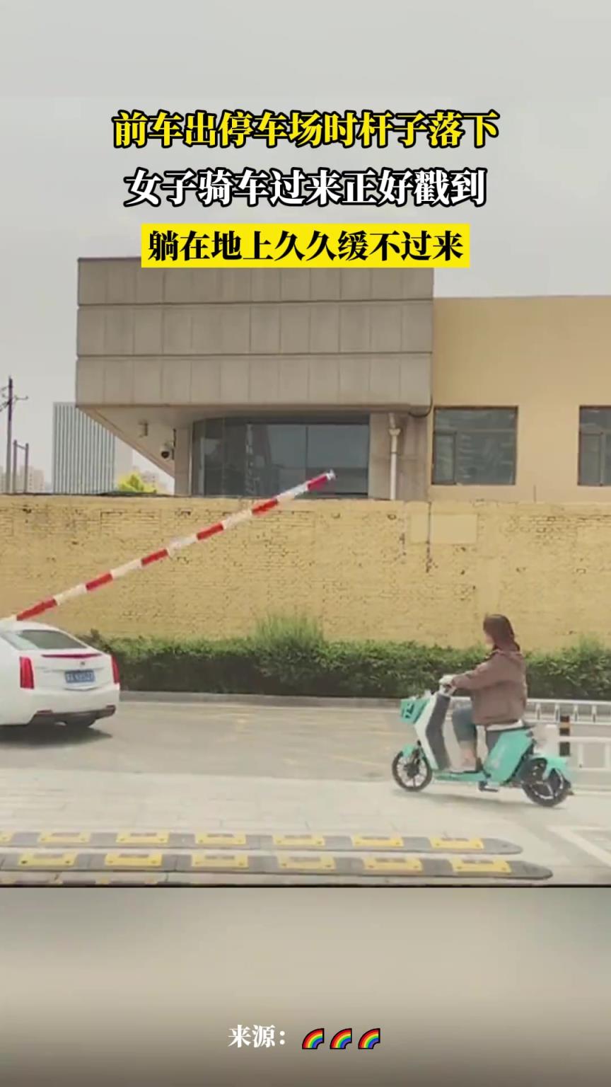 前车出停车场时杆子落下，女子骑车过来正好截到