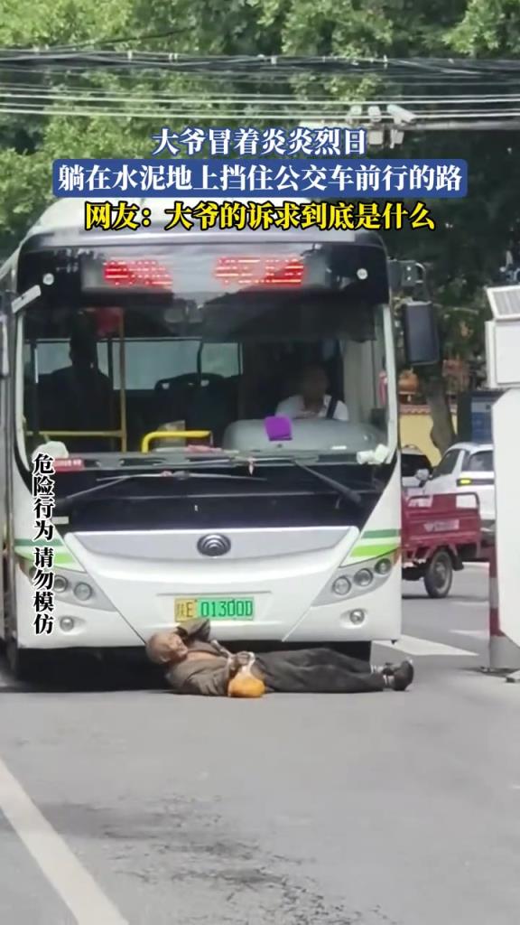 大爷冒着炎炎烈日，躺在水泥地上挡住公交车前行的路