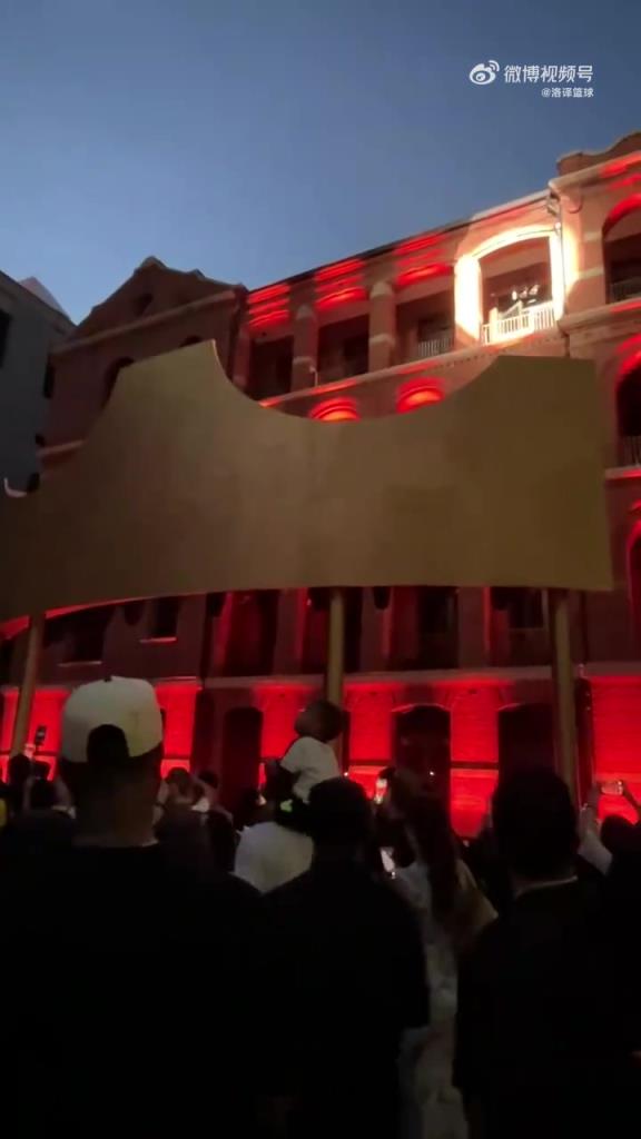 詹姆斯中国行站在四层高的建筑拱门中，向上海球迷问候致意！